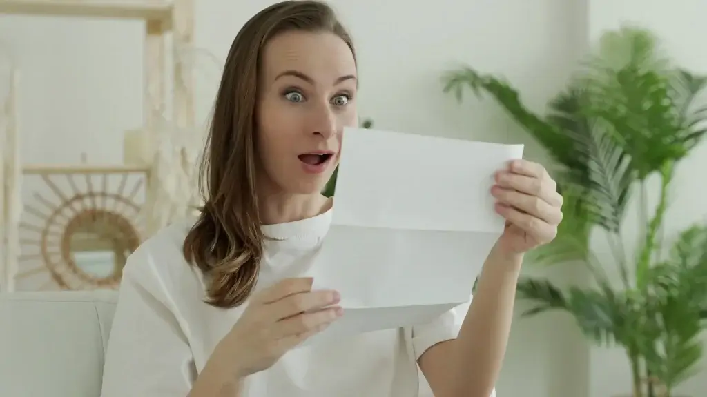 Mulher segurando documentos e olhando surpresa, representando dúvidas sobre Invalidez Absoluta e Definitiva no seguro de vida.