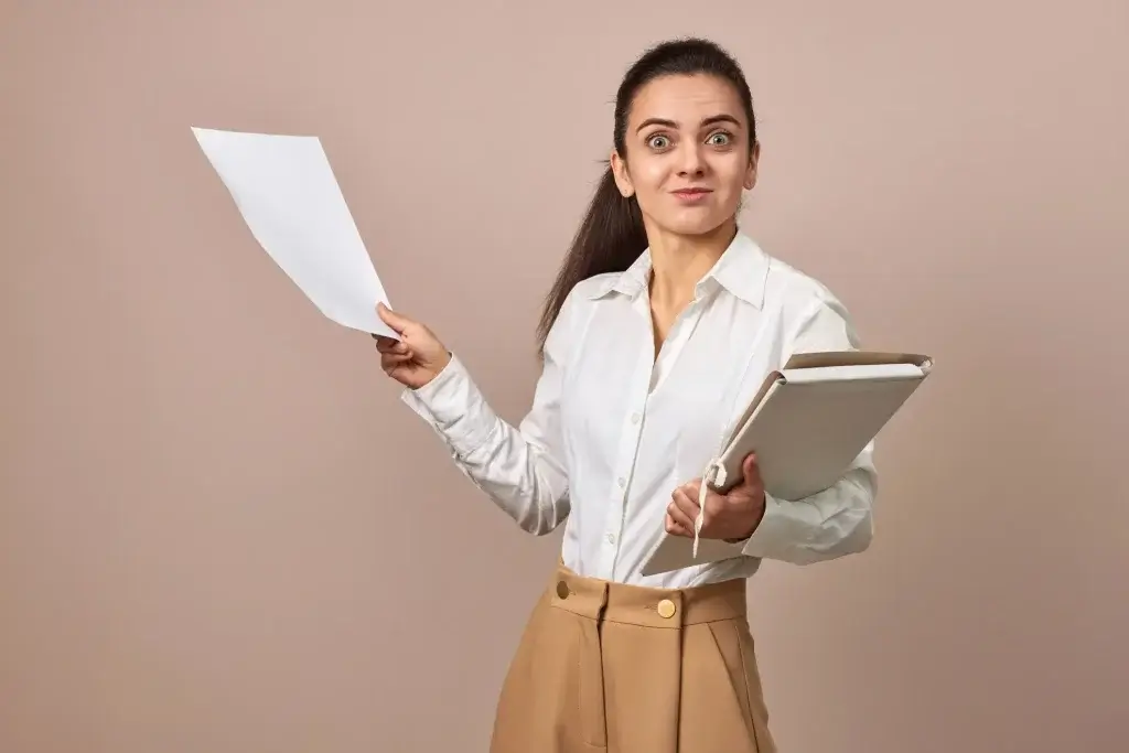 Mulher segurando documentos e olhando surpresa, representando dúvidas sobre Invalidez Absoluta e Definitiva no seguro de vida.